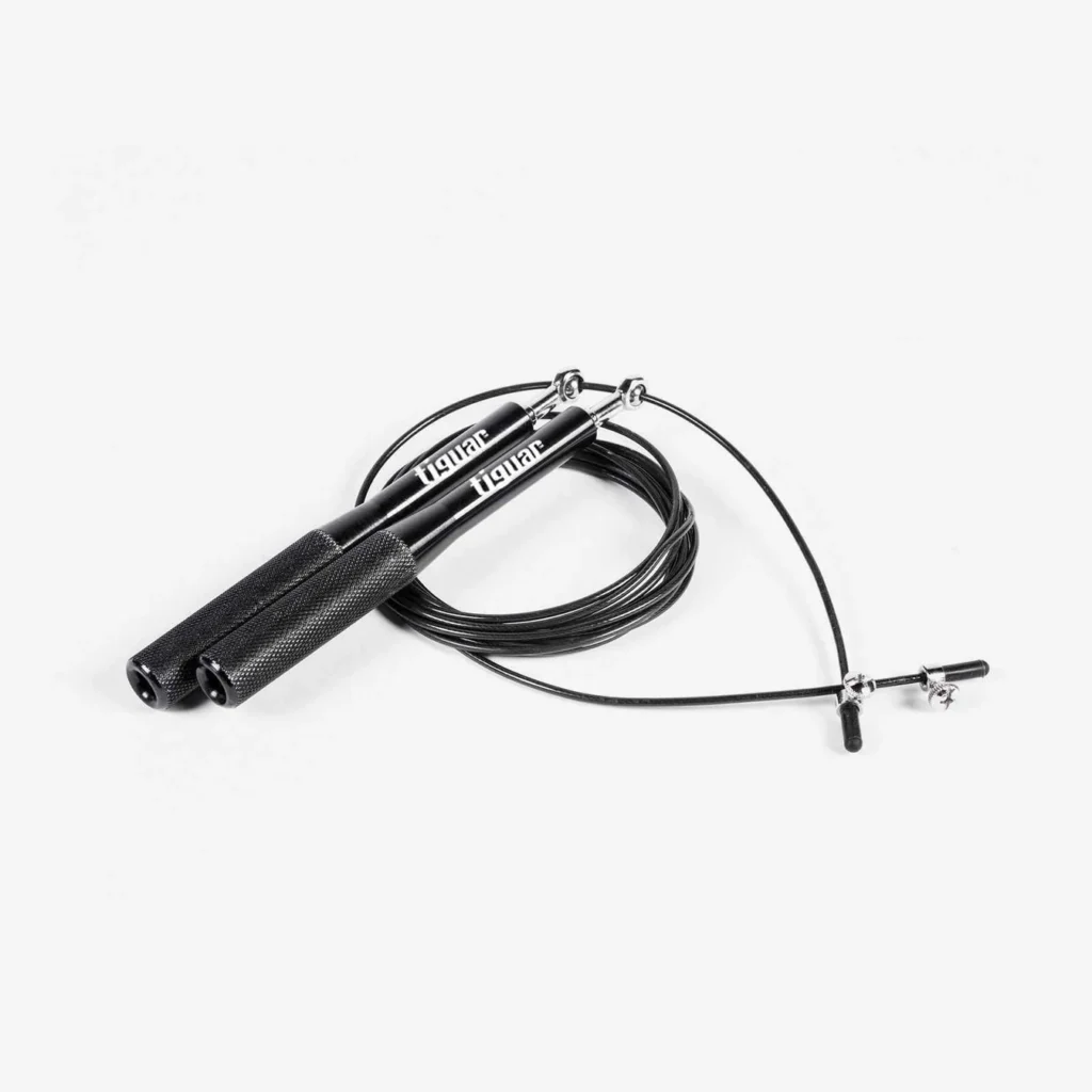 Ein schwarzes Springseil mit strukturierten Griffen und einem dünnen, aufgerollten Kabel, abgebildet auf einem weißen Hintergrund. Der Markenname Ignite ist auf den Griffen aufgedruckt.
