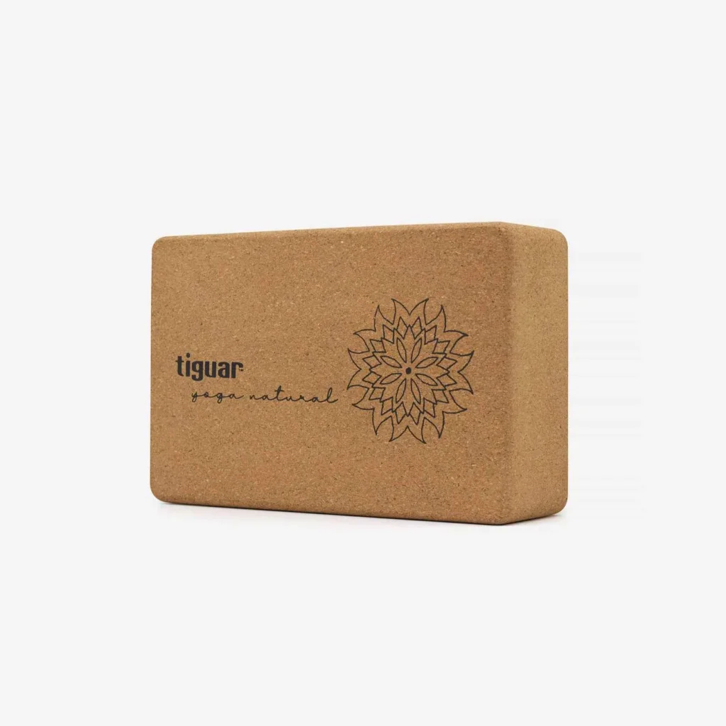Ein rechteckiger Yogablock aus Kork mit abgerundeten Kanten, der auf einer Seite das Logo der Marke tiguar und ein dekoratives Blumendesign auf weißem Hintergrund trägt.
